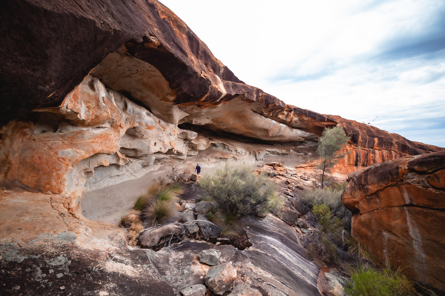 A person hiking through the huge granite deposits at Cave Hill near Coolgardie