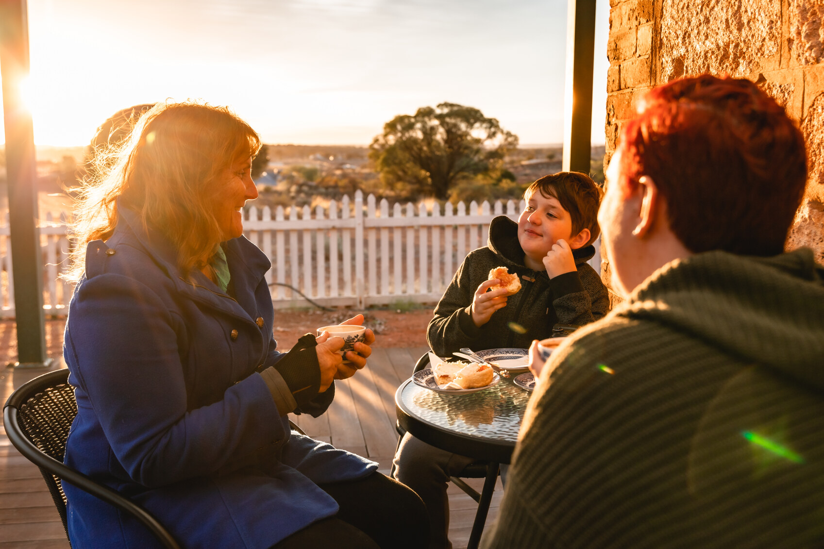 A family eating on the terrace at Warden Finnerty's Residence Coolgardie