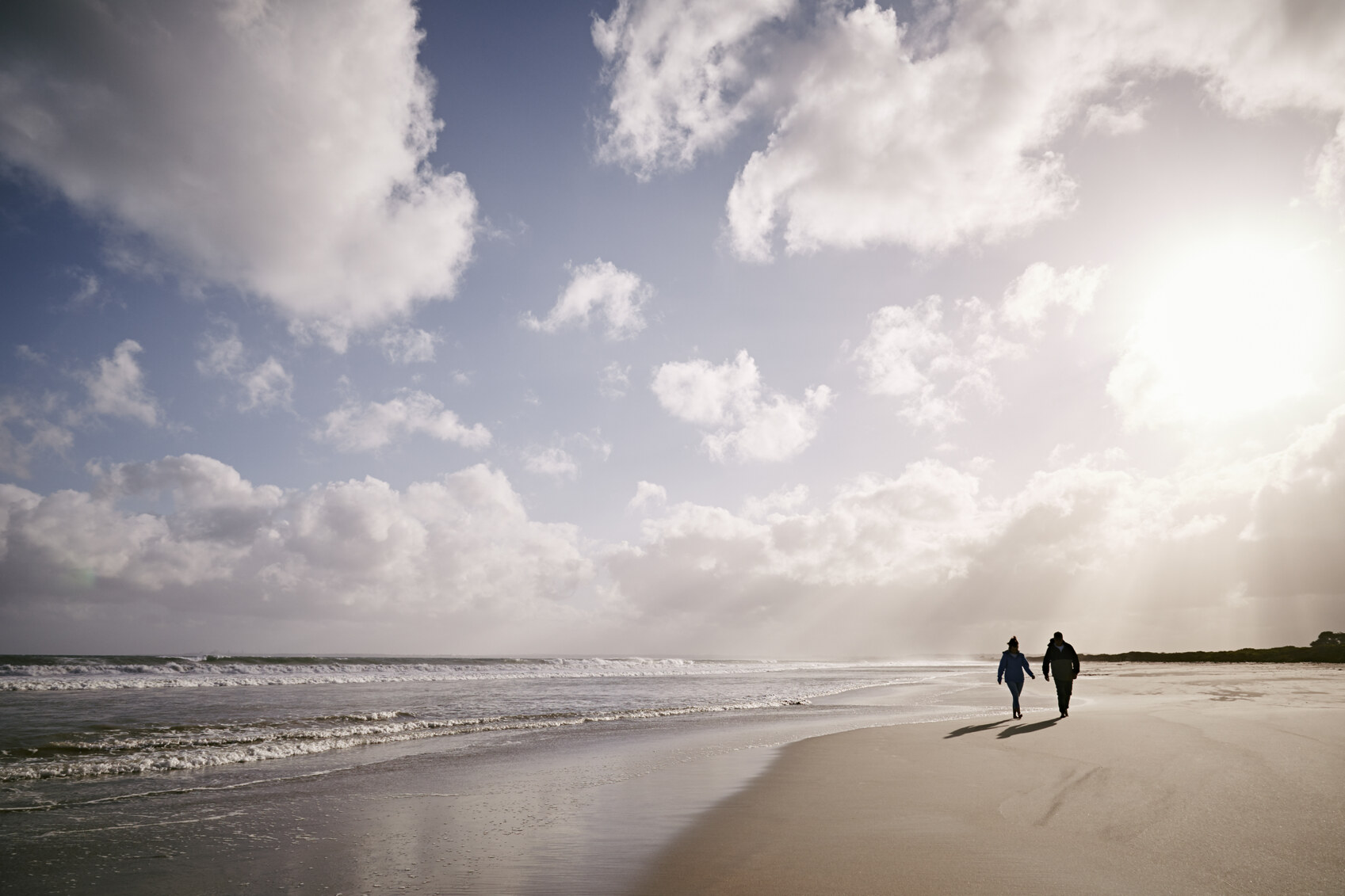 A couple walk on a beach on the Discovery Coast Glenelg Shire Victoria