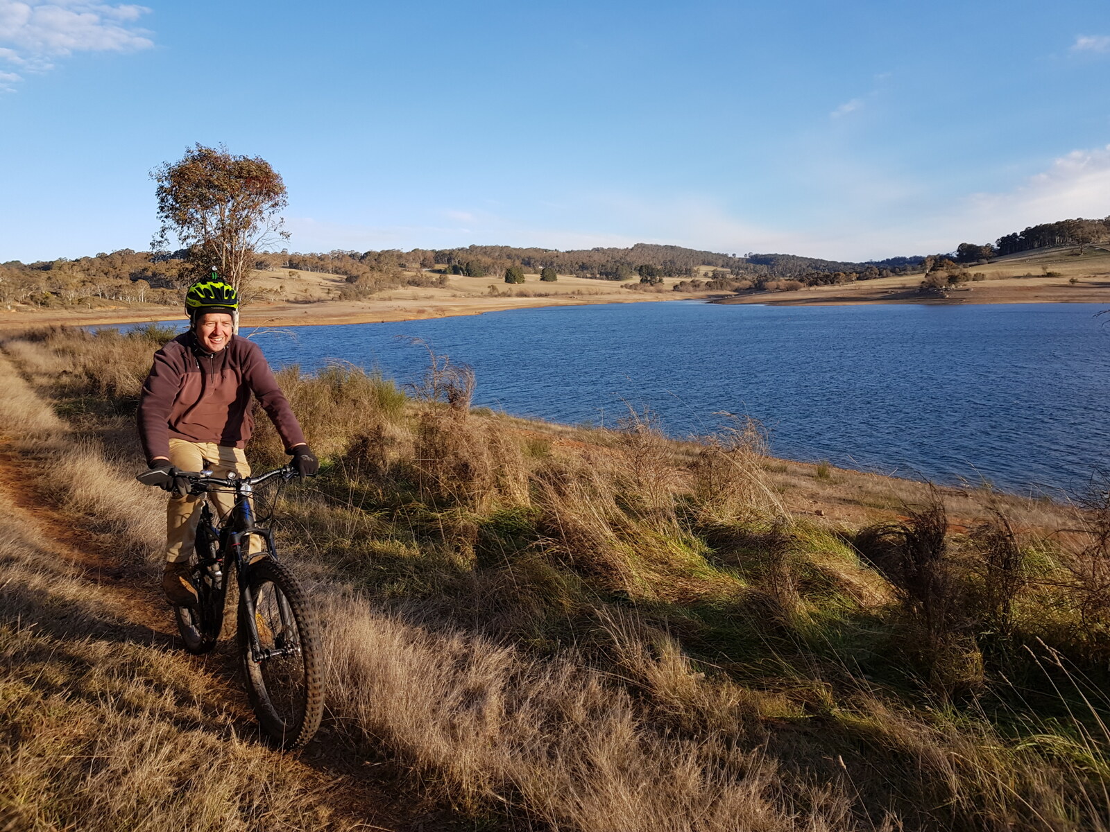A man on a bike cycling around Lake Oberon in NSW Australia